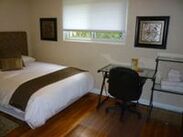 bed with white linens desk window